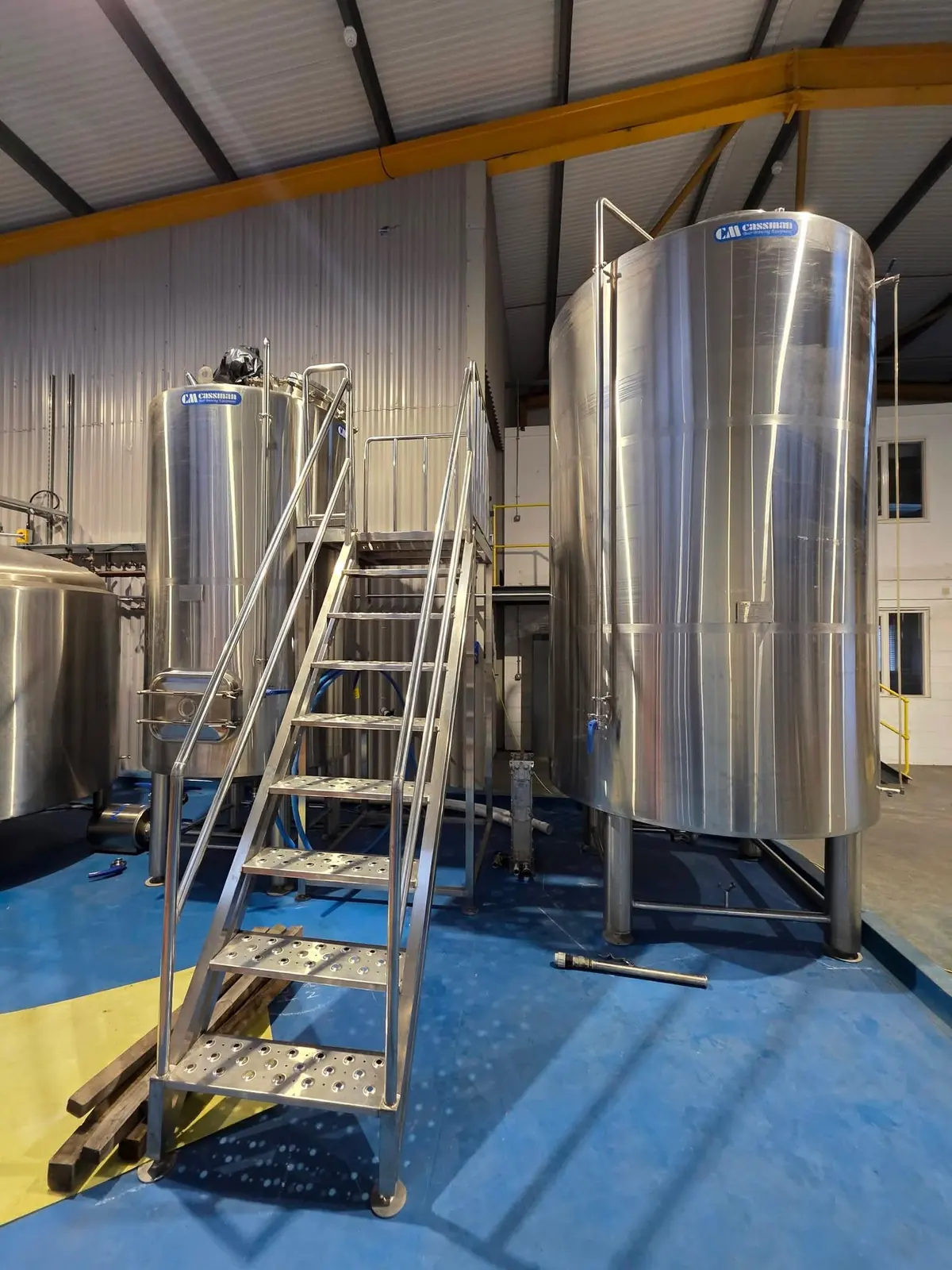 Stainless steel brewery vessels with access stairs and platform