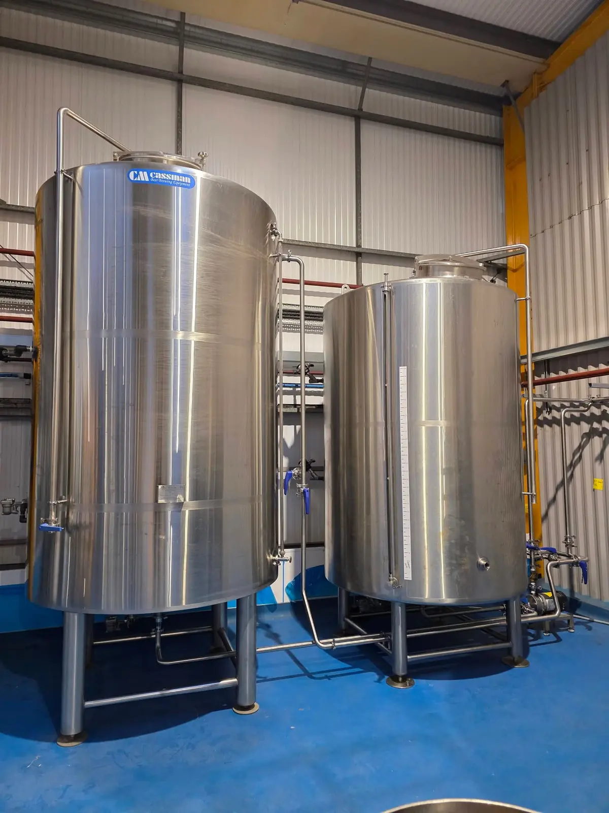 Two stainless steel brewery vessels linked by hygienic pipework