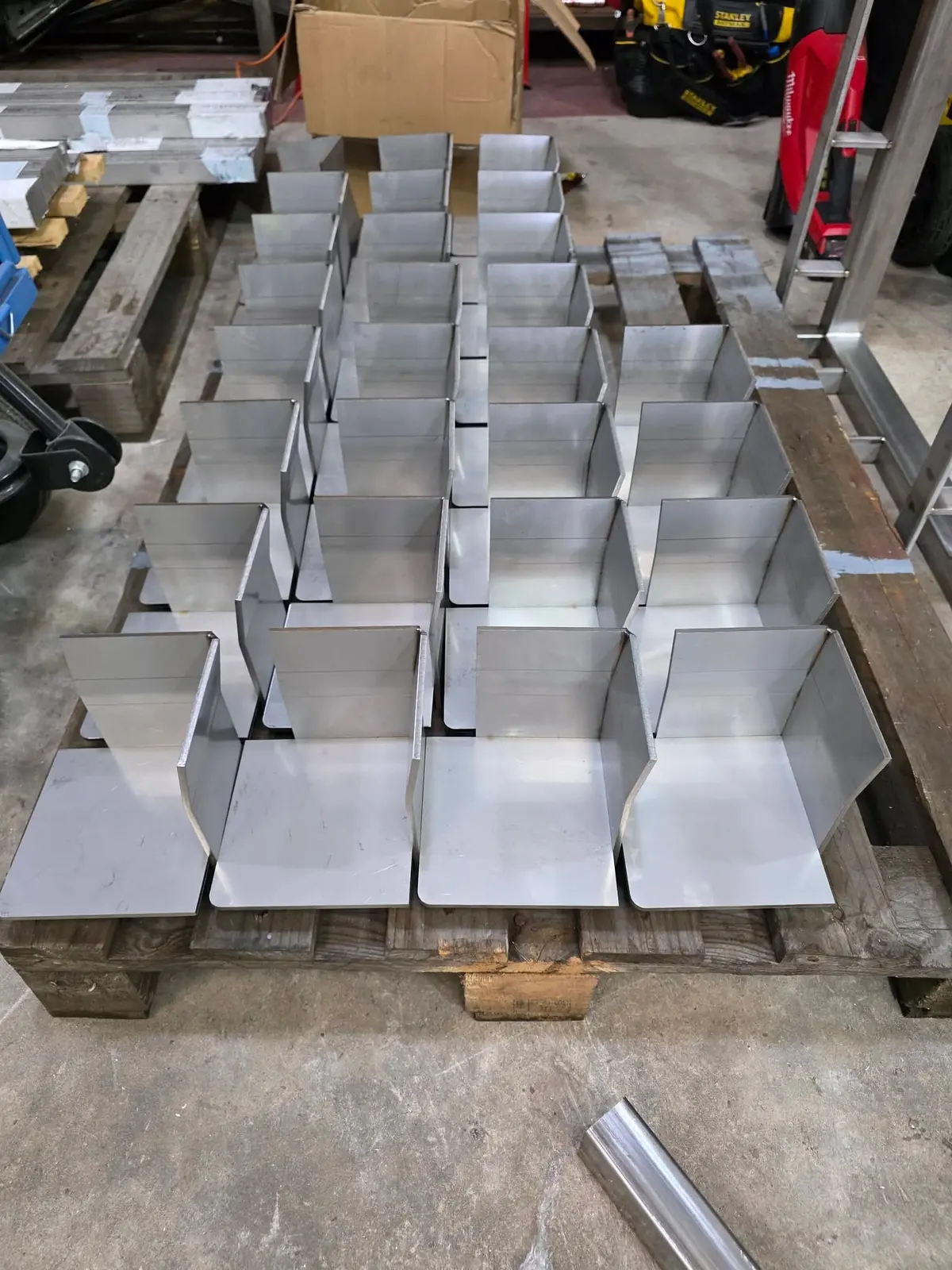 Fabricated stainless steel support brackets laid out on a pallet