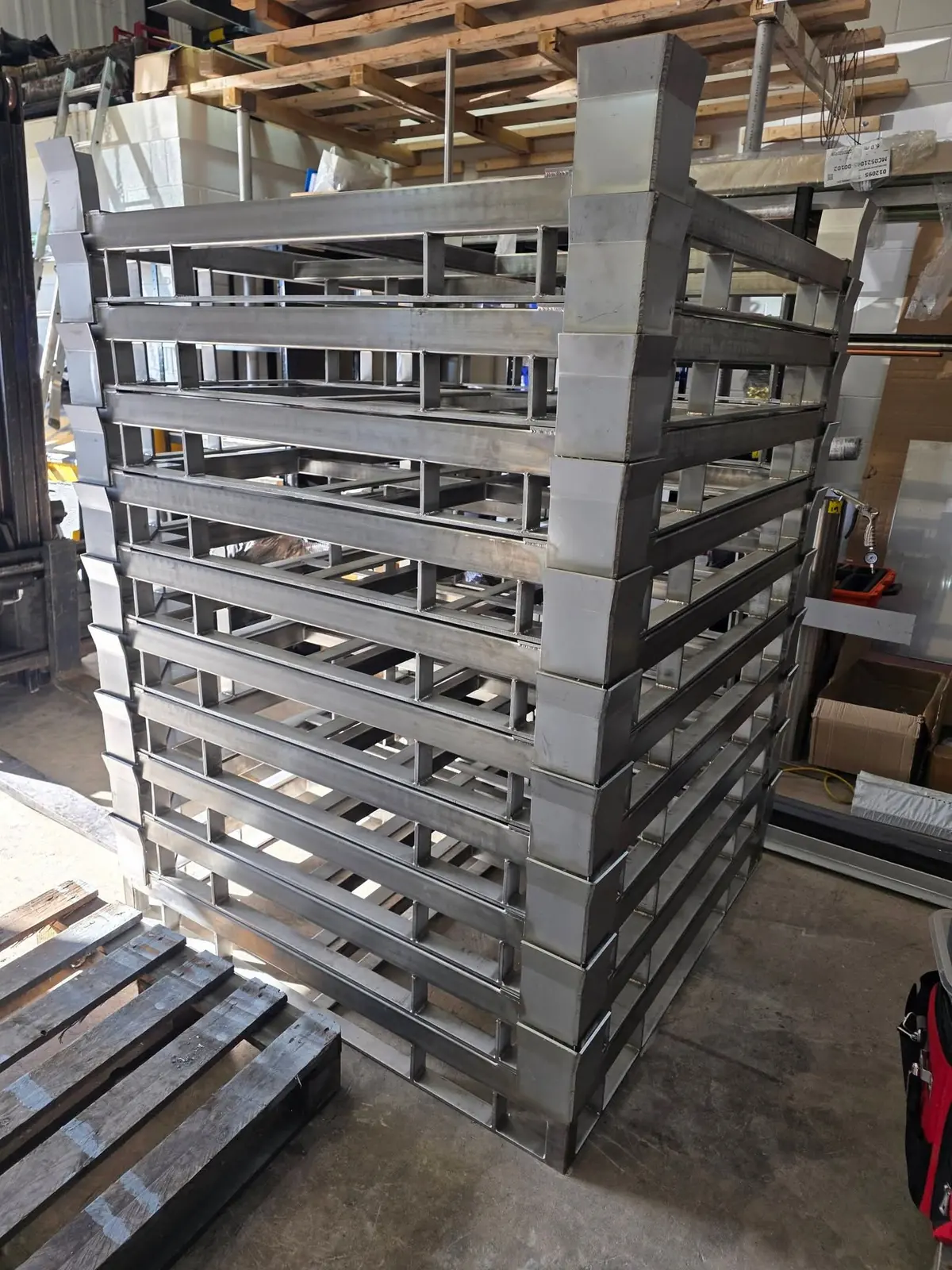 Stack of fabricated stainless steel IBC frames in the workshop