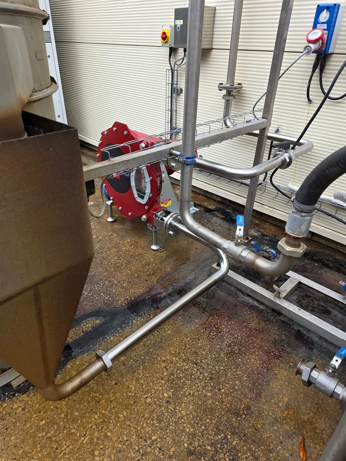 Stainless steel pipework connecting a hose pump to a tank