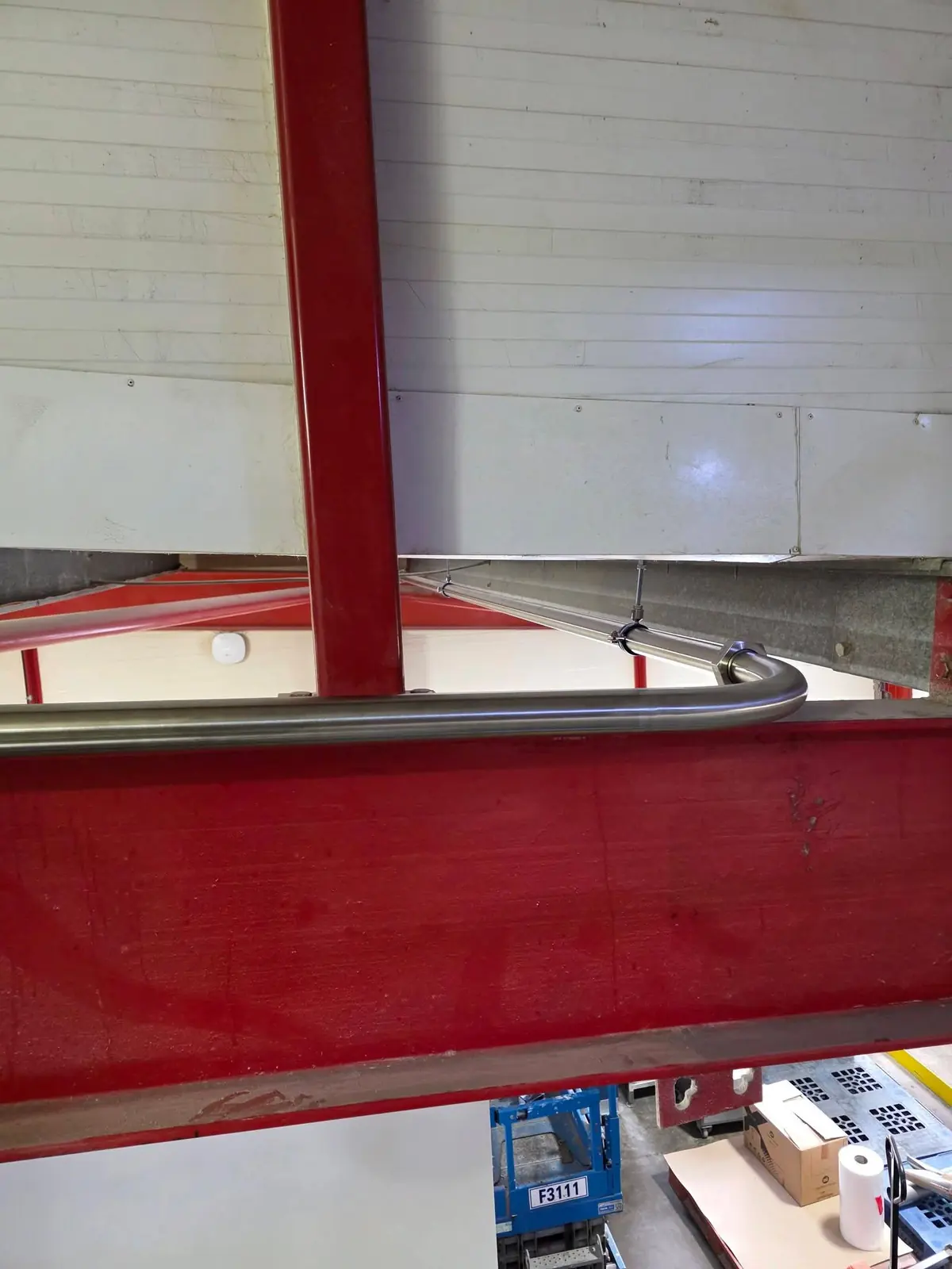 Stainless steel vacuum line bending around a steel beam